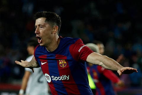 Barcelona's Robert Lewandowski celebrates scoring his side's third goal against Valencia at the Olimpic Lluis Companys stadium in Spain. 