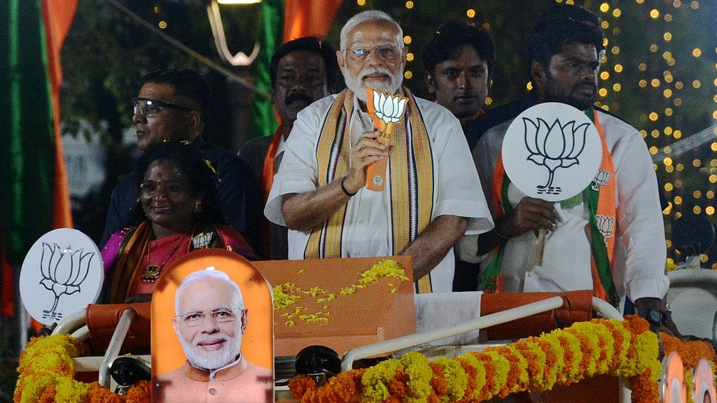 AP : Indian Prime Minister Narendra Modi, center, rides in an open vehicle holding party symbol lotus as he campaigns for Bharatiya Janata Party (BJP) for the upcoming national elections, in Chennai, India.