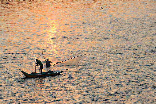 Photo via Getty : Fishermen Fishing Silhouette during Sunset at Ennore Creek, North Chennai, Tamil Nadu in India