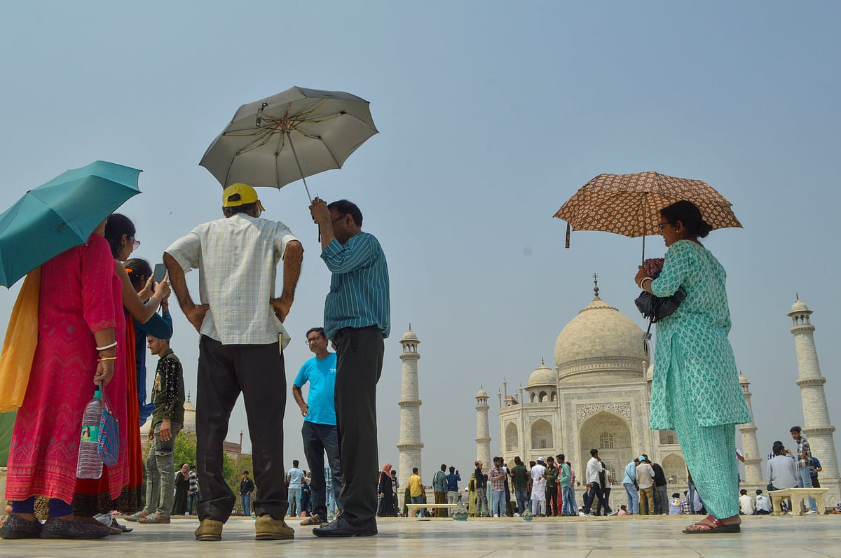 PTI : Tourists holding umbrellas visit the Taj Mahal on a hot summer day, in Agra, Sunday, April 14, 2024.
