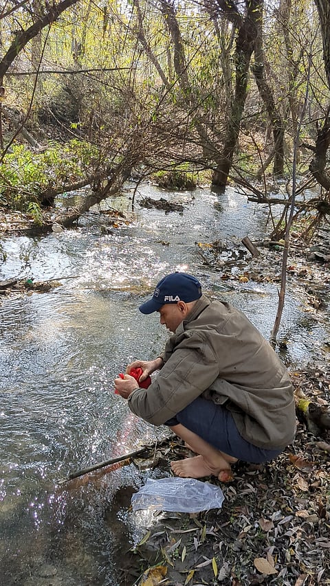 Vishal immersing last remains in the brook near the cremation ground at the native village Trail Srigupwara, Anantnag Kashmir . November 4, 2023
