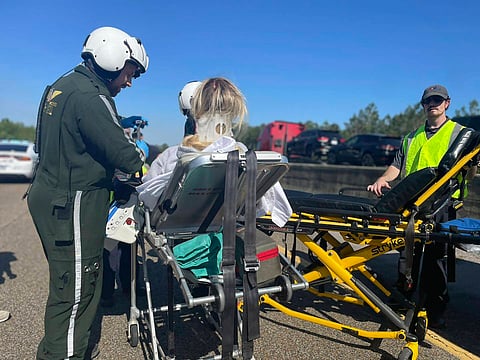 In this photo provided by the Mississippi Highway Patrol, first responders tend to a passenger from a bus after it blew a tire and hit a concrete barrier on Interstate 10, near Bay St. Louis, Miss., Friday, April 5, 2024.