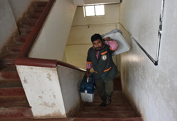  (Photo by Arijit Sen via Getty Images)
 : A Bruhat Bengaluru Mahanagara Palike (BBMP) staff carries Electronic Voting Machines (EVM) at the mustering centre in Kamlabai Girls High School on May 11, 2018 in Bengaluru, India. (Representational Photo)