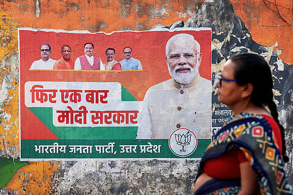 Representative Image/Getty Images : A woman walks past an election campaign poster of the Bharatiya Janata Party (BJP) featuring their leader and India's Prime Minister Narendra Modi (R), along a street in Varanasi on March 24, 2024, ahead of the country's upcoming general elections.