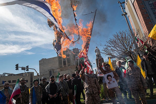Members of the Islamic Revolutionary Guard Corps (IRGC) are burning flags of Israel and the U.S. during a funeral for members of the IRGC Quds Force who were killed in an Israeli air strike in Syria, in Tehran, Iran, on April, 2024.  - Getty Images