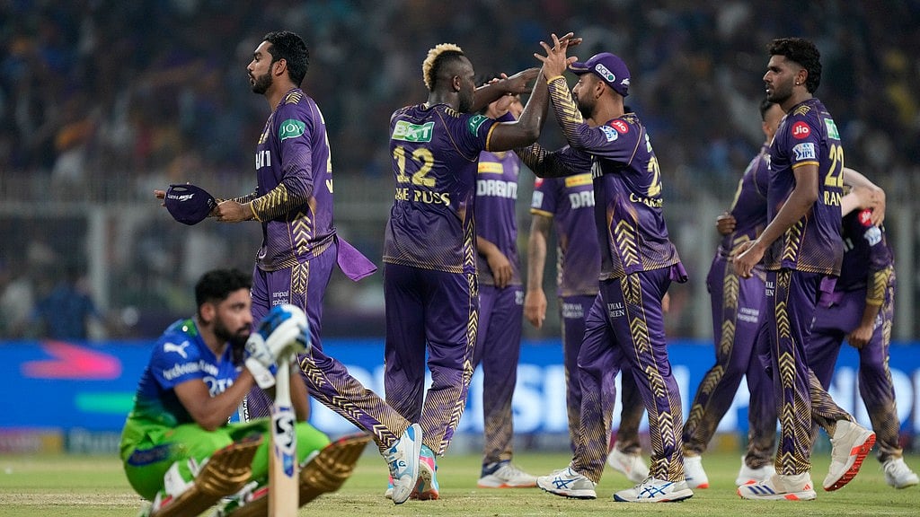 Royal Challengers Bengaluru's Mohammed Siraj sits dejected as Kolkata Knight Riders celebrate their win in match 36 of Indian Premier League 2024 at Eden Gardens. - AP/Bikas Das