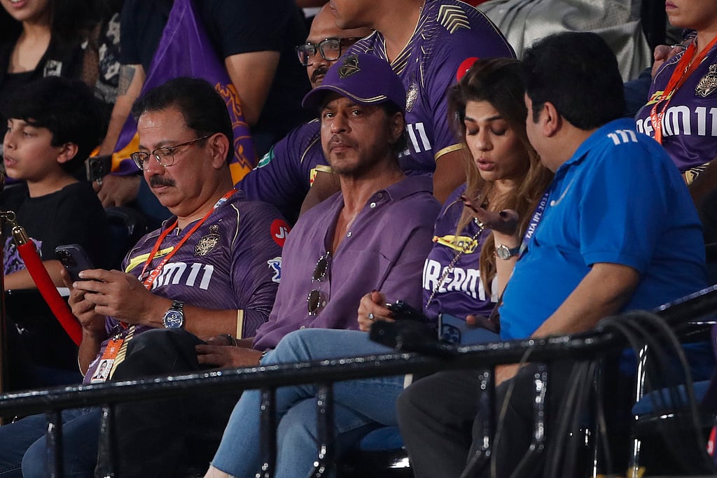 Shah Rukh Khan (c) watches from the stands.