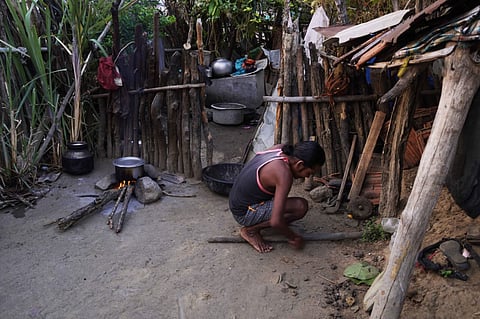 Vilas Talande cutting firewood at his home.