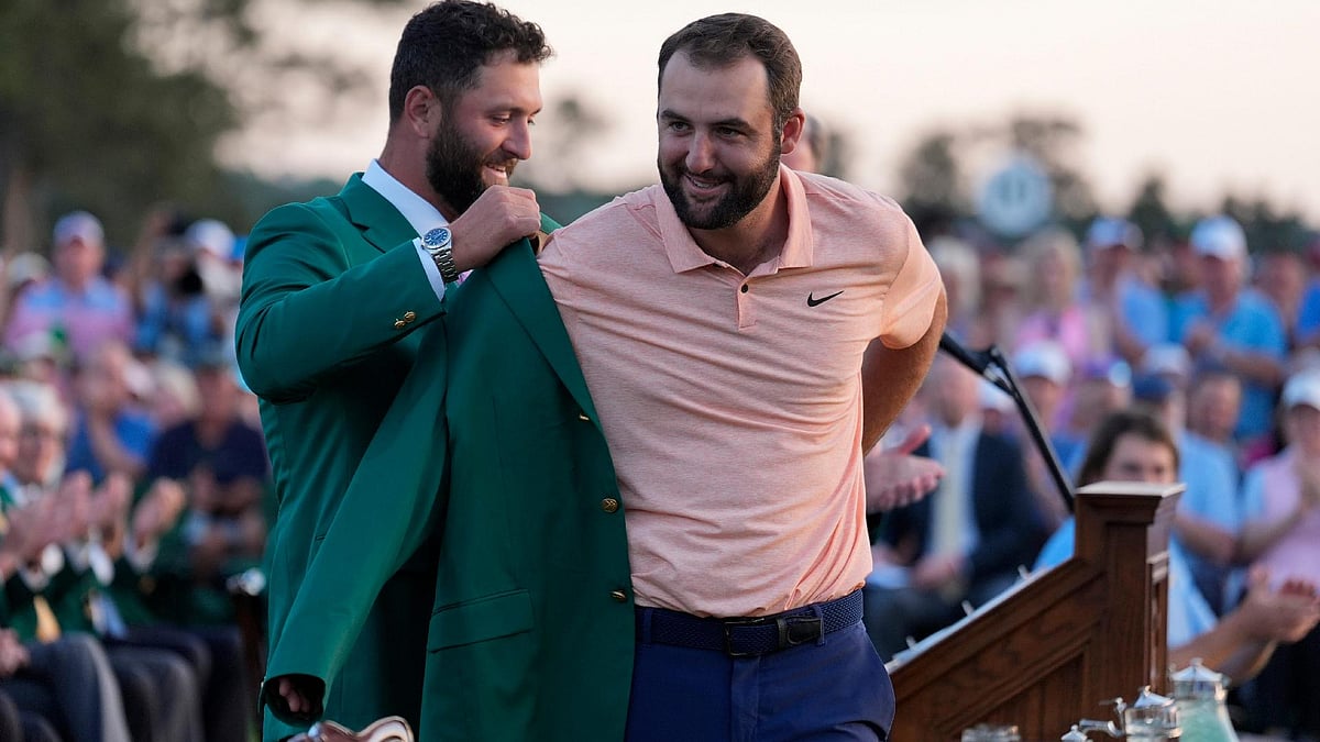 Ashley Landis/AP : Jon Rahm (left) puts the green jacket on winner Scottie Scheffler after the 88th Masters.