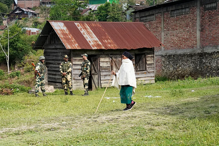 An elderly woman arrives at a polling station to cast her vote in Shangshak village, in the northeastern Indian state of Manipur, Friday, April 26, 2024. - AP
