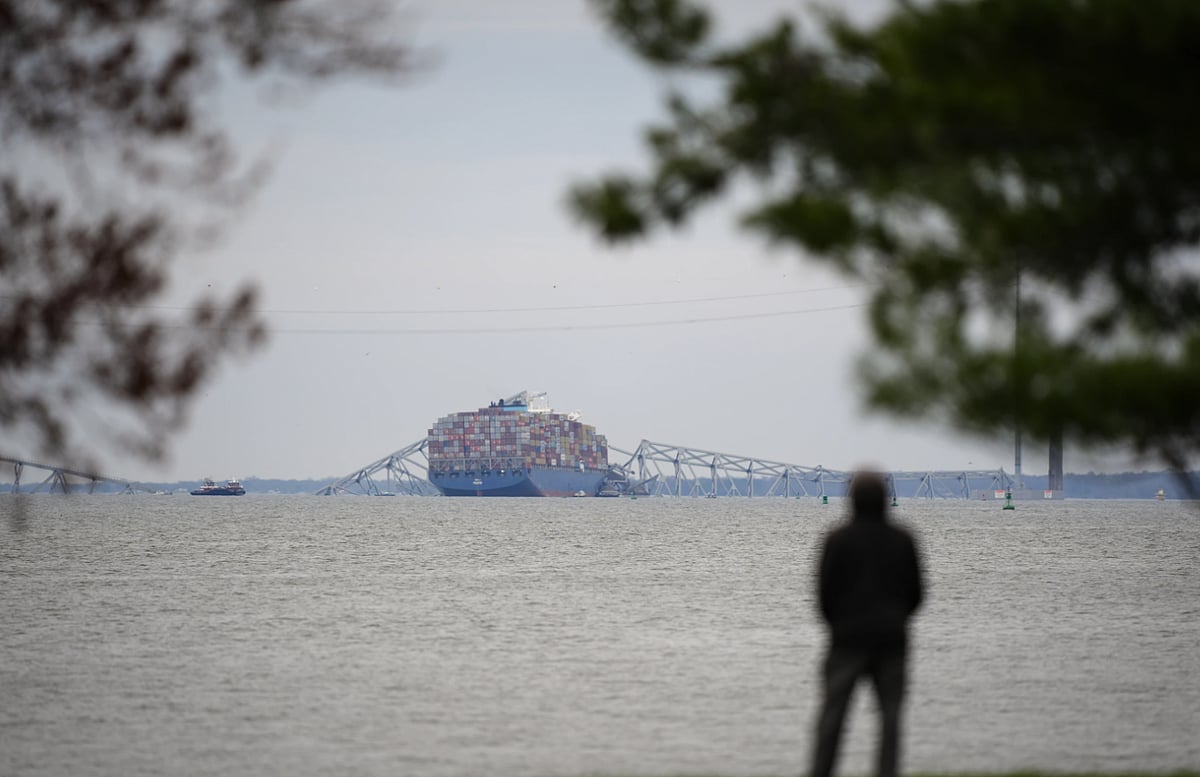 AP : A person views from Fort McHenry a container ship as it rests against the wreckage of the Francis Scott Key Bridge. 