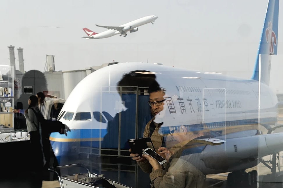 AP : Passengers walk past a couple browsing their smartphones near a China Southern Airlines, parked on the tarmac at the Beijing Capital International Airport Saturday, Nov. 19, 2016. China’s Commerce Ministry said Thursday, May 30, 2024, it will restrict exports of aviation and aerospace-related equipment and technology beginning July 1, 2024 |