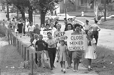 Mothers carrying protest signs accompany their children to Graymont Elementary School in Birmingham, Ala., which was opened on an integrated basis, Sept. 4, 1963.