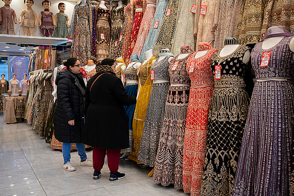 Getty Images : Two women customers browse garments in a retail business