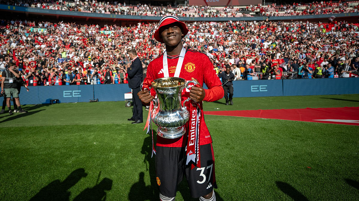 Kobbie Mainoo celebrates with the FA Cup trophy, as the England midfielder hopes to make the Euro 2024 squad next month. - null