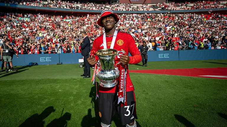 Kobbie Mainoo celebrates with the FA Cup trophy, as the England midfielder hopes to make the Euro 2024 squad next month. - null