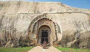 Barabar Hill Caves, where an ancient stone wall guards the entrance to a hidden cave world.