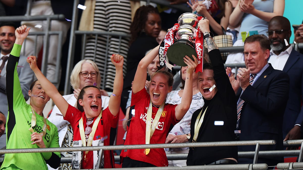 Marc Skinner lifts the Women's FA Cup trophy with Millie Turner on Sunday