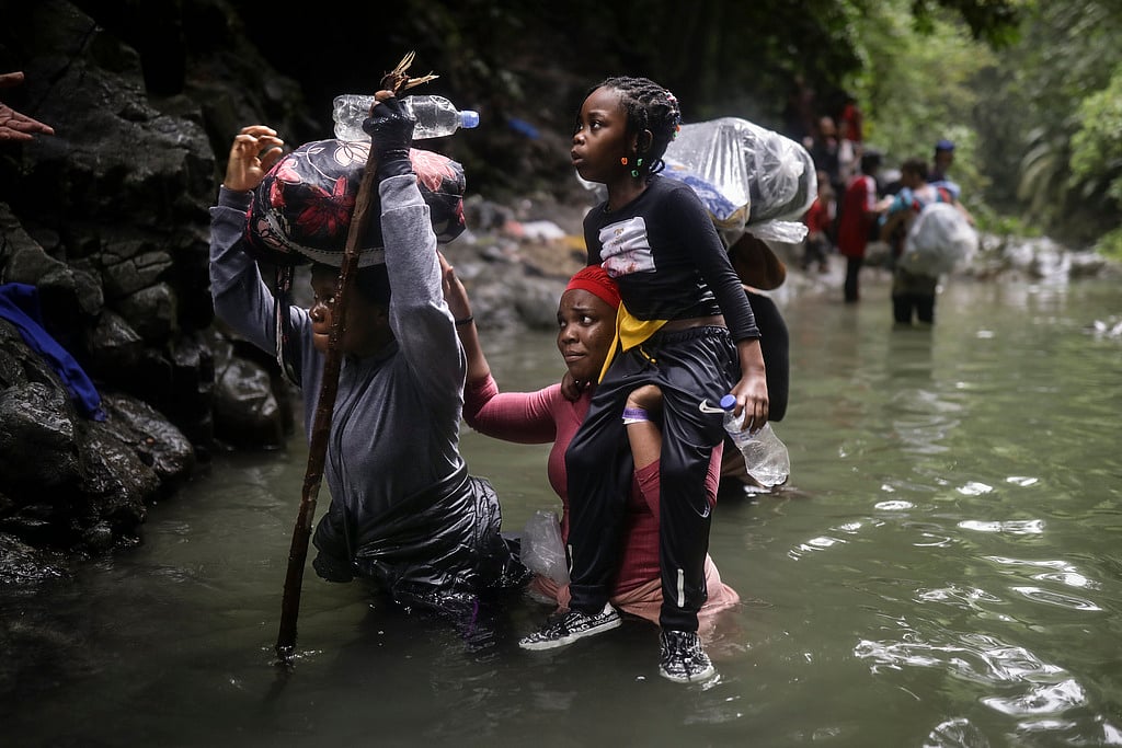 AP : Haitian migrants wade through water as they cross the Darien Gap from Colombia to Panama in hopes of reaching the U.S., Tuesday, May 9, 2023. Haiti 's extremely vulnerable to climate change--a crisis exacerbated by natural disasters.