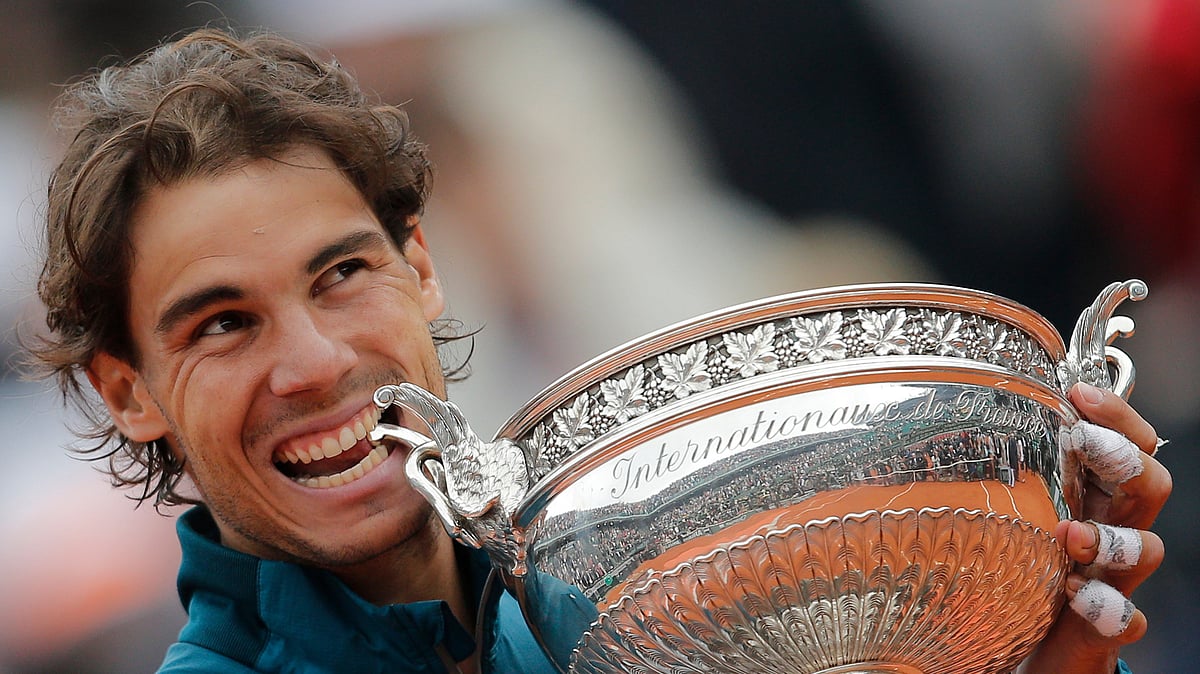 AP : Spain's Rafael Nadal bites the trophy after winning against compatriot David Ferrer in three sets 6-3, 6-2, 6-3, in the final of the French Open tennis tournament, at Roland Garros stadium in Paris, Sunday June 9, 2013.