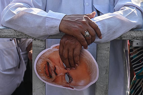  (Photo by Kabir Jhangiani Getty Images) : A man is holding a face mask of Indian Prime Minister Narendra Mod