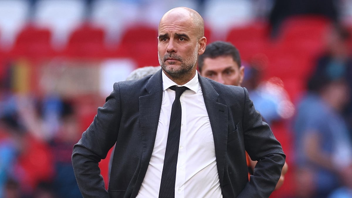 Pep Guardiola looks on as Man Utd lift the FA Cup.