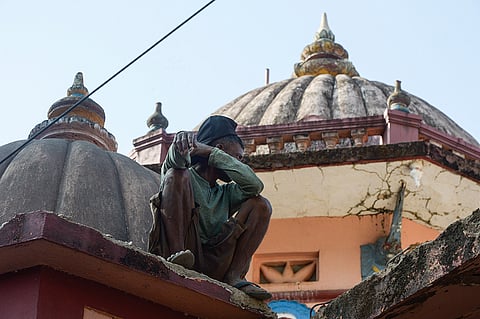 A boy sitting atop a wall at Shri Gajanta Lakshmi Temple, Marcel, Goa.