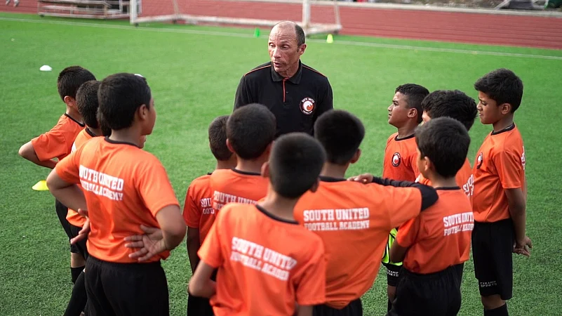 Former Chelsea and Manchester City player Terry Phelan interacting with kids in South United Football Academy.