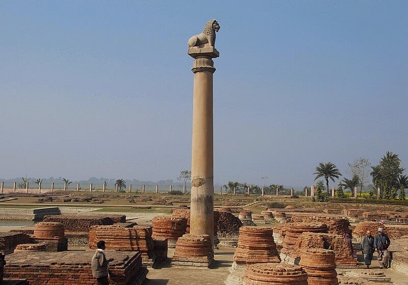 A majestic lion perched atop a grand column, part of the iconic pillars of Ashoka.