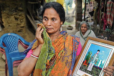 Tragic Memories: Pabitra Samanta’s wife holds a picture of her deseased brother-in-law, Subrata