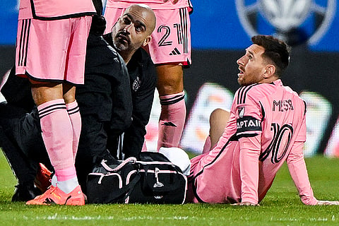 Injured Lionel Messi with team trainers
