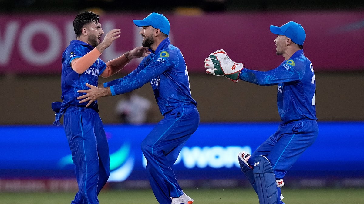 Photo: AP Photo/Ramon Espinosa : Afghanistan's Fazalhaq Farooqi, left, celebrates the dismissal of New Zealand's Daryl Mitchell during an ICC Men's T20 World Cup cricket match at Guyana National Stadium in Providence, Guyana.