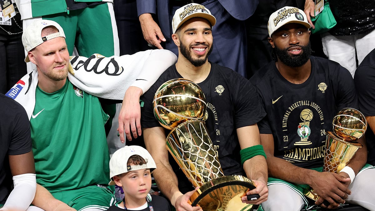 (Left to right) Kristaps Porzingis, Jayson Tatum and Jaylen Brown celebrate the Boston Celtics' 2023-24 NBA title. - null