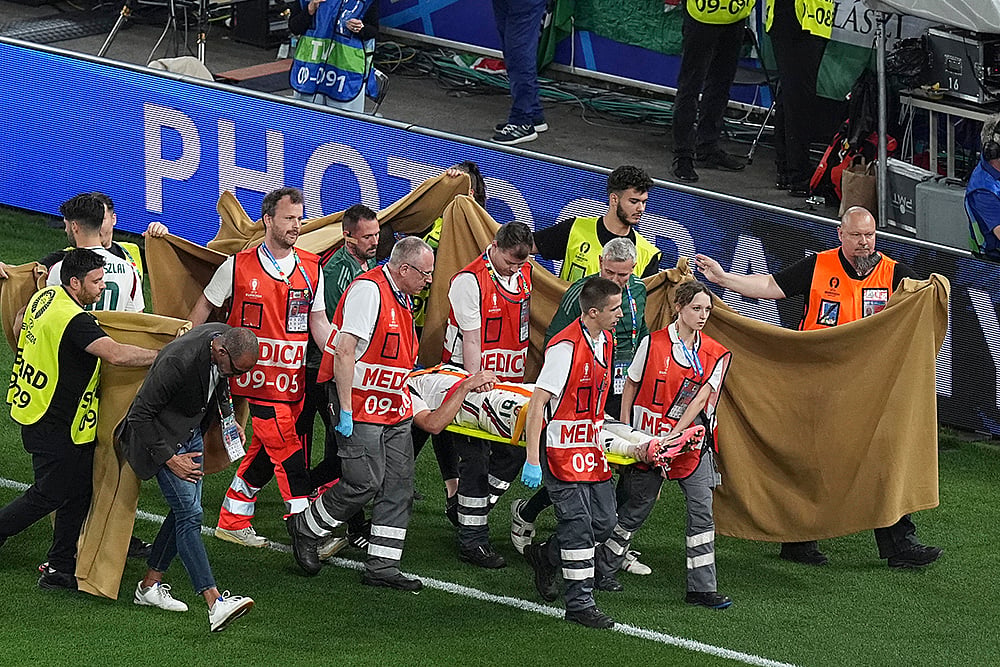 | Photo: AP/Ariel Schalit : Barnabas Varga is carted off the pitch after an injury
