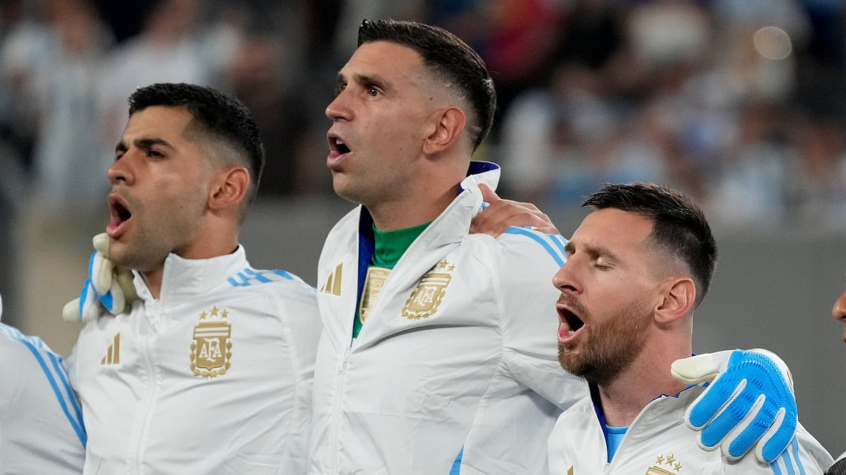 Argentina's Lionel Messi, right, and Cristian Romero flank goalkeeper Emiliano Martinez while singing the national anthem before the Copa America Group A football match against Chile in East Rutherford. - AP Photo/Pamela Smith