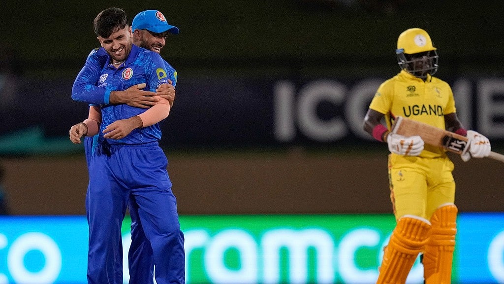 Photo: Ramon Espinosa : Afghanistan pacer Fazalhaq Farooqi, left, celebrates the wicket of Uganda's Ronak Patel during their ICC T20 World Cup 2024 cricket match at Guyana National Stadium. 