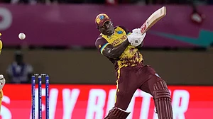 AP Photo/Ramon Espinosa : West Indies captain Rovman Powell plays a shot to be caught by Uganda's Robinson Obuya for 23 runs during an ICC Men's T20 World Cup cricket match at Guyana National Stadium in Providence, Guyana.
