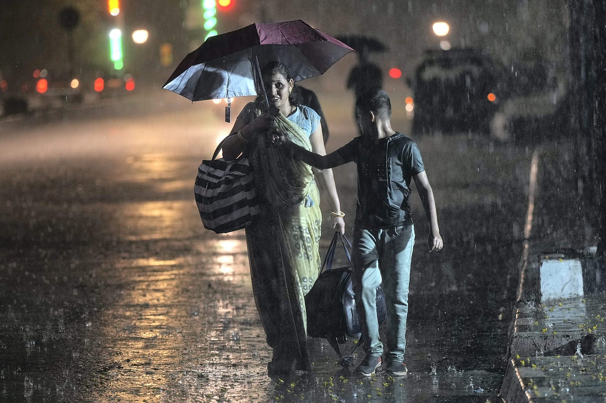 PTI : A pedestrian uses an umbrella to shield herself during rains, outside CSMT in Mumbai, Sunday, June 9, 2024. 