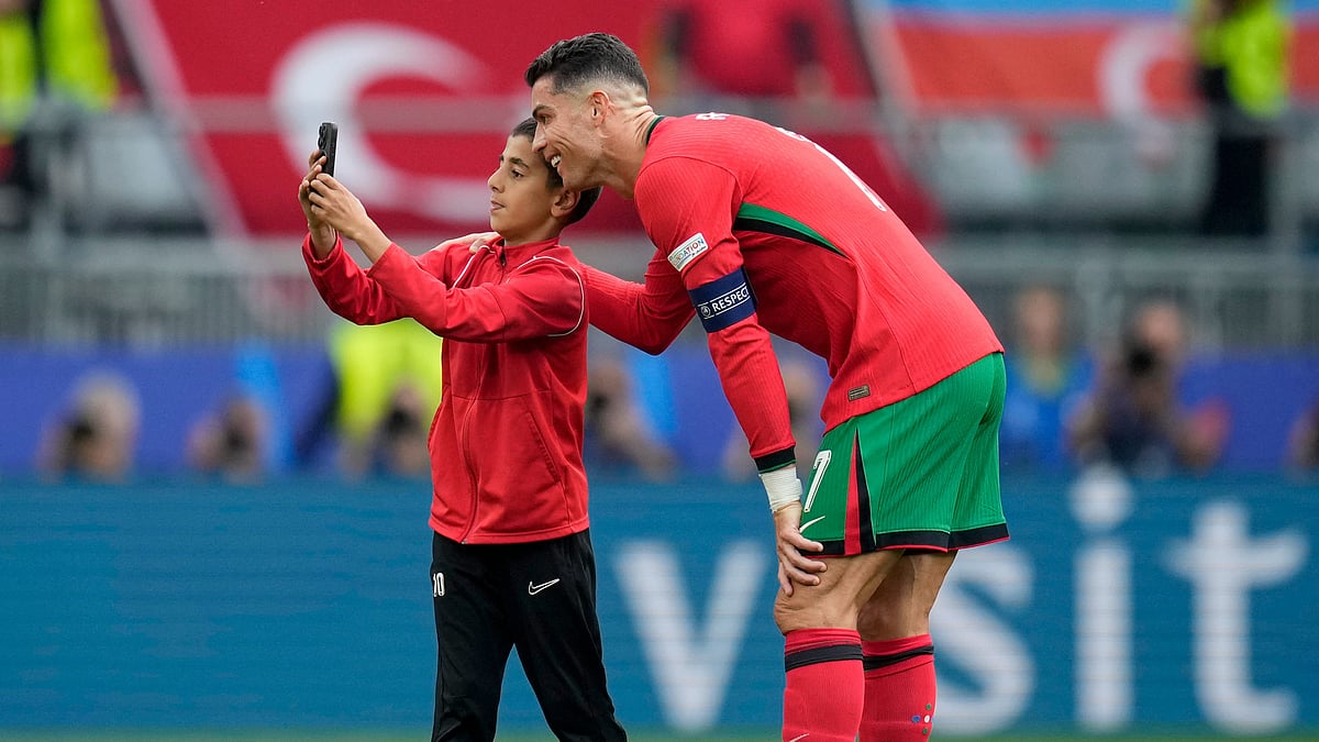 A young pitch invader takes a selfie with Portugals Cristiano Ronaldo 