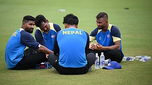 Photo: X/ @CricketNep : Nepal cricket team players resting during the practice session in the USA.