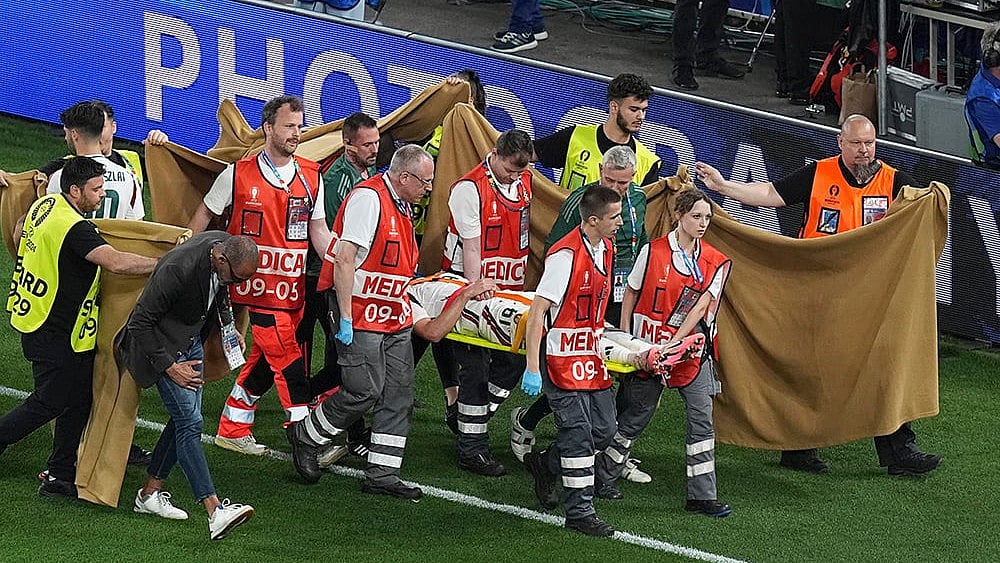 | Photo: AP/Ariel Schalit : Barnabas Varga is carted off the pitch after an injury