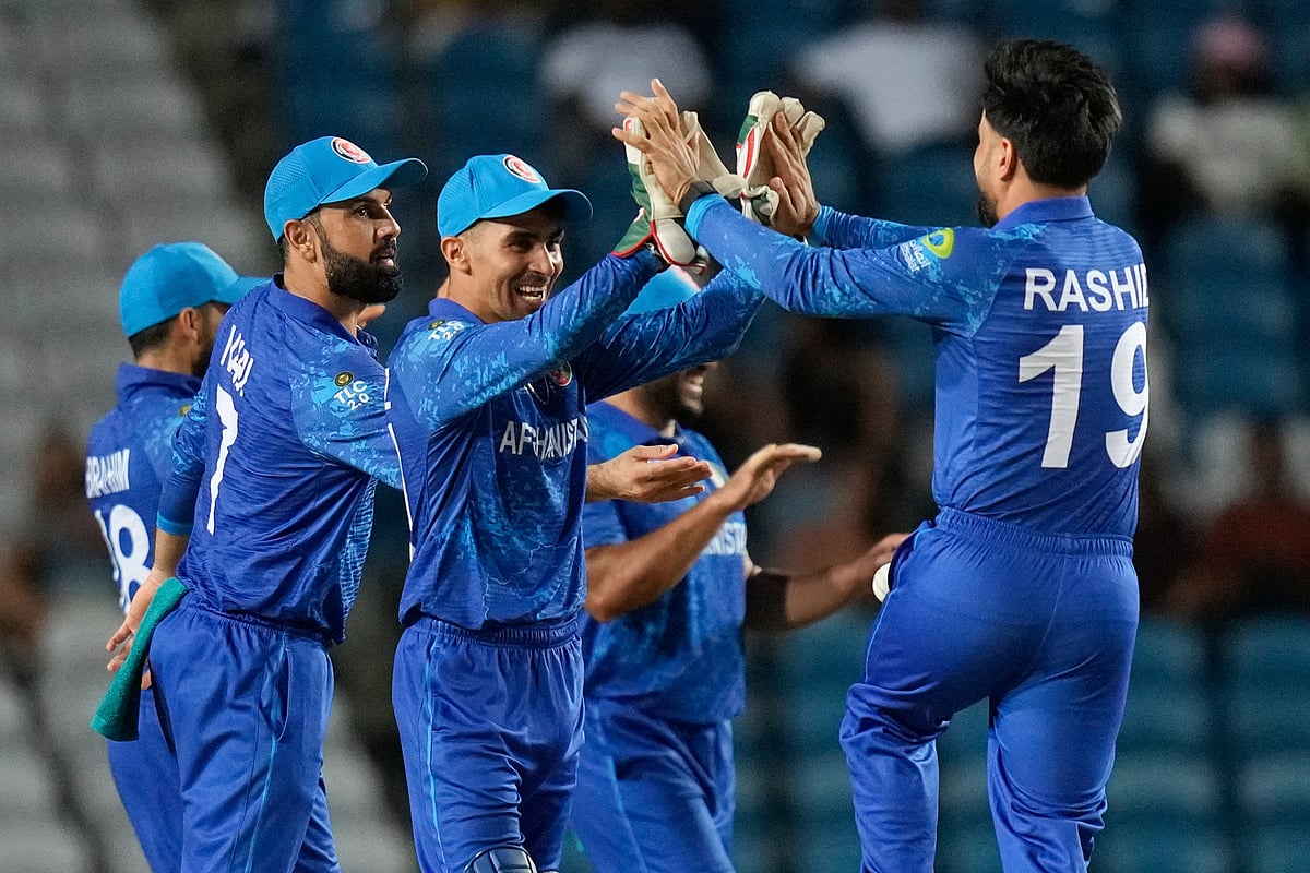 (AP Photo/Ramon Espinosa)
 : Afghanistan's wicket keeper Rahmanullah Gurbaz, second from left, celebrates with captain Rashid Khan the dismissal of Papua New Guinea's Lega Siaka during an ICC Men's T20 World Cup cricket match at Brian Lara Cricket Academy in Tarouba, Trinidad and Tobago, Thursday, June 13, 2024. 