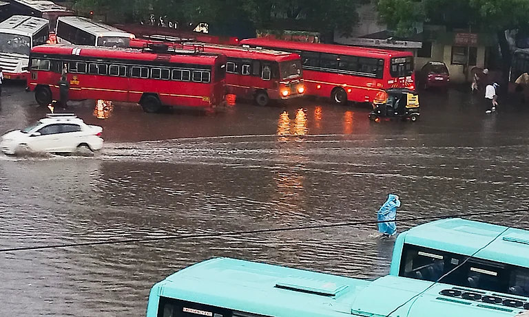 Pune: Commuters wade through a waterlogged road amid rains, in Pune, Saturday, June 8, 2024. - PTI