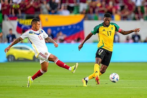 Damion Lowe passes the ball in front of Darwin Machis 