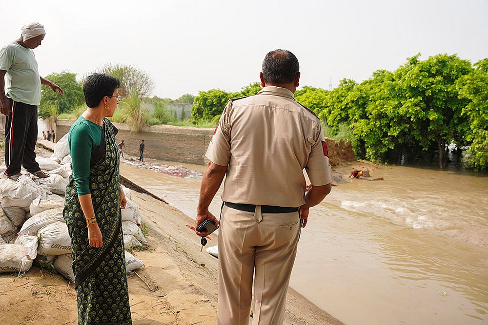 Delhi Water Minister Atishi inspects a flooded area after a breach in Munak canal