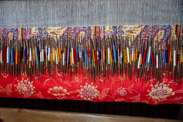 Wooden needles and pashmina yarn are being used to weave a traditional Kani Shawl on a loom in a shawl weaving factory on the outskirts of Srinagar. A traditional Kani Shawl in Kashmir, showcasing the exquisite craftsmanship and detailed artistry that have been revered since the Mughal Era. - Getty Images