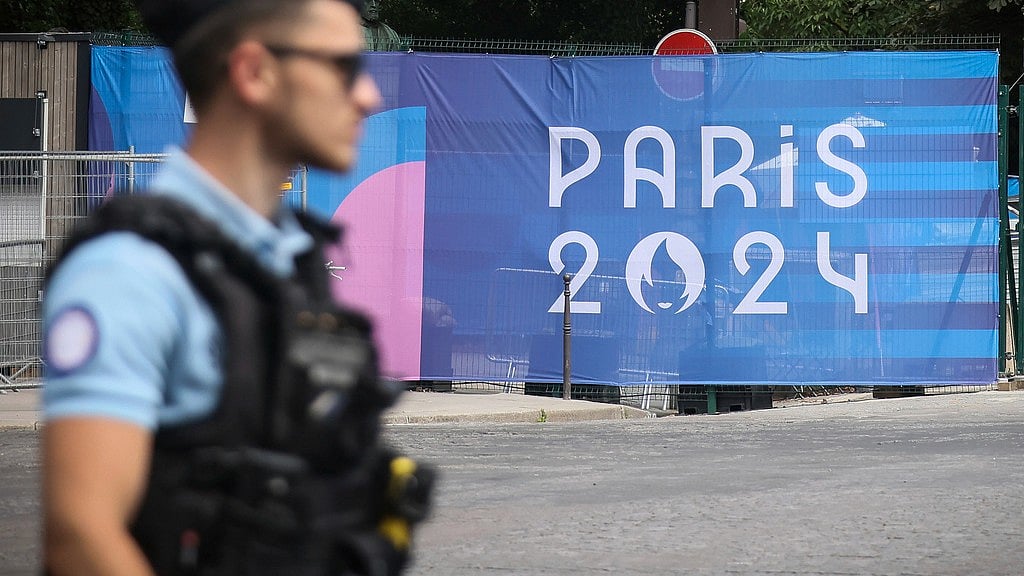 A police officer walks past a Paris olympics canvas at the 2024 Summer Olympics, Saturday, July 20, 2024, in Paris, France. - AP/Thomas Padilla
