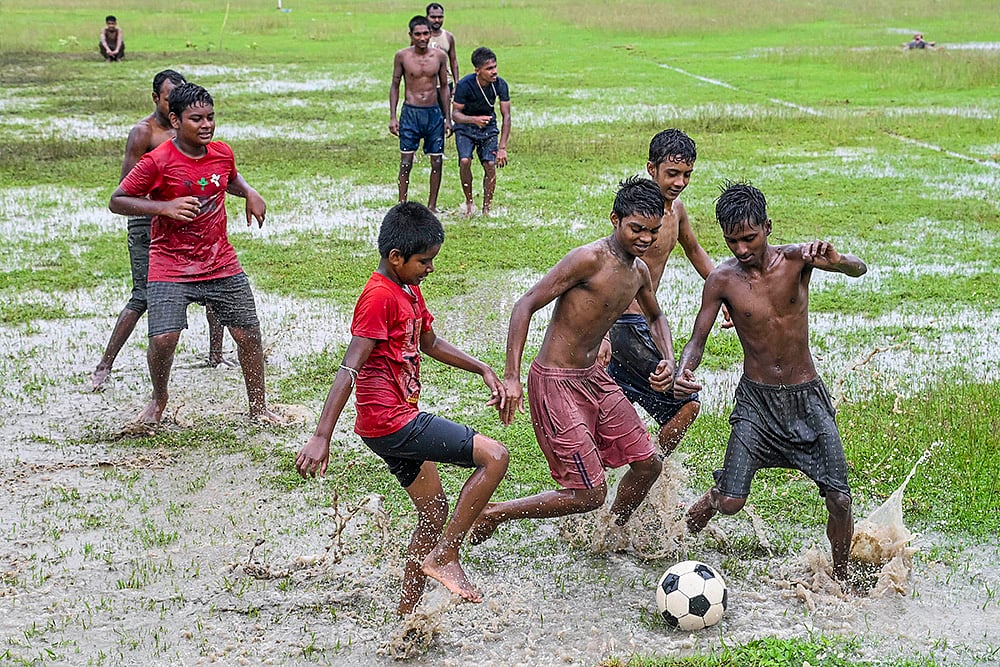 Children play football in rains