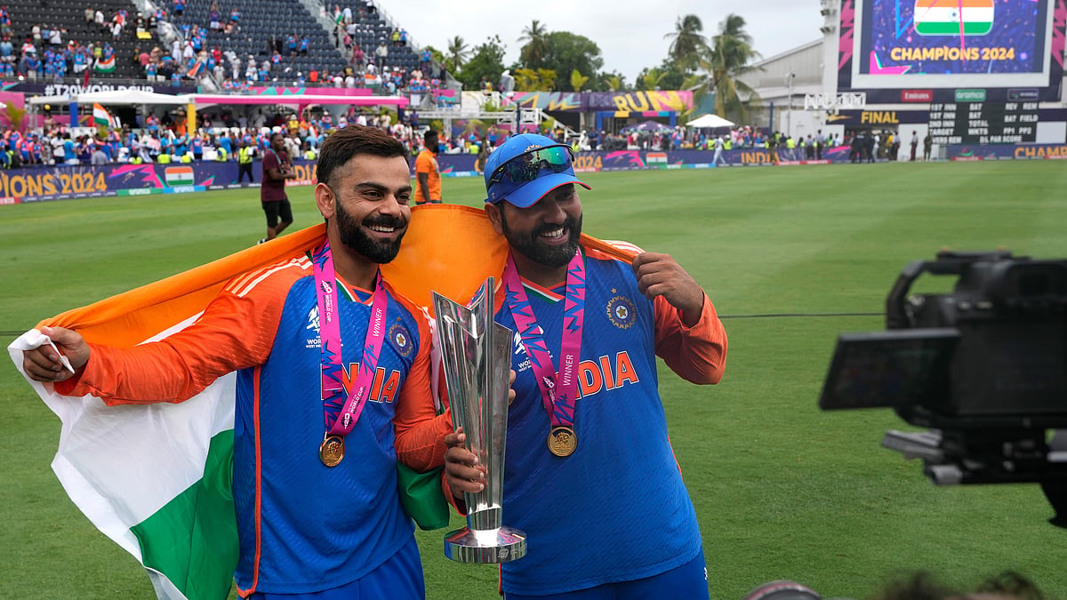 India's Virat Kohli, left, and captain Rohit Sharma pose with the winners trophy after defeating South Africa in the ICC Men's T20 World Cup final cricket match at Kensington Oval in Bridgetown, Barbados, Saturday, June 29, 2024.  - (AP Photo/Ricardo Mazalan)
