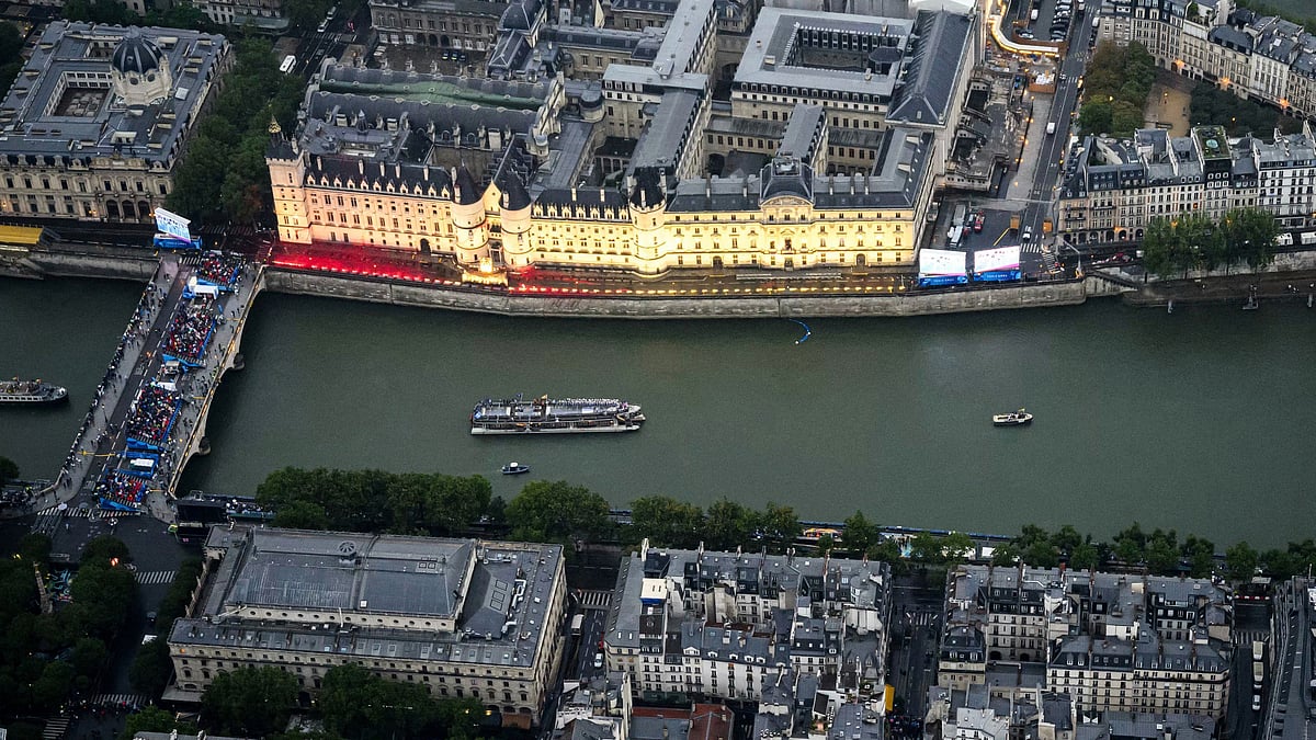 Lionel Bonaventure/Pool Photo via AP : Boats carrying athletes float along the river Seine past the Concergerie in Paris, France, during the opening ceremony for the 2024 Summer Olympics, Friday, July 26, 2024.